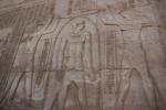 Hieroglyphics carved into stone on the side of an Egyptian temple