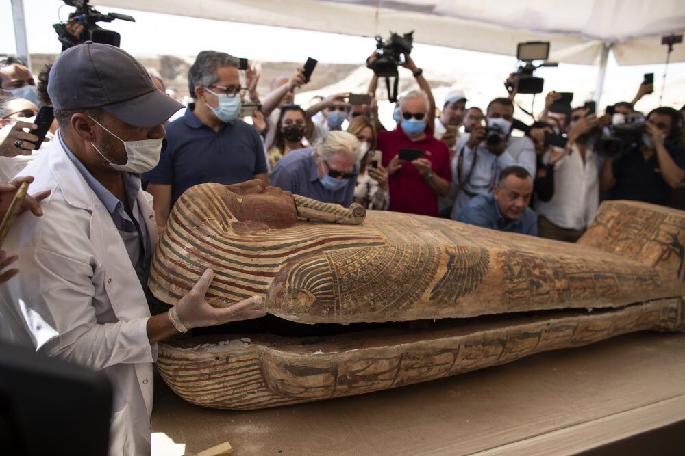 An archeology worker opens a sarcophagus at the Saqqara archaeological site, 30 kilometers (19 miles) south of Cairo, Egypt, on Saturday, Oct. 3, 2020, in the presence of journalists and officials.